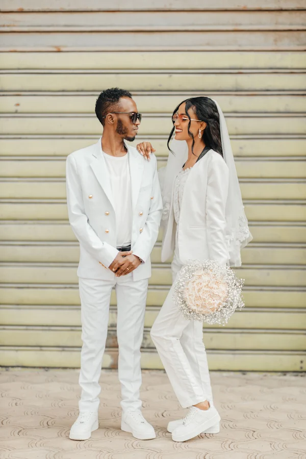 A stylish couple in matching white suits on their wedding day